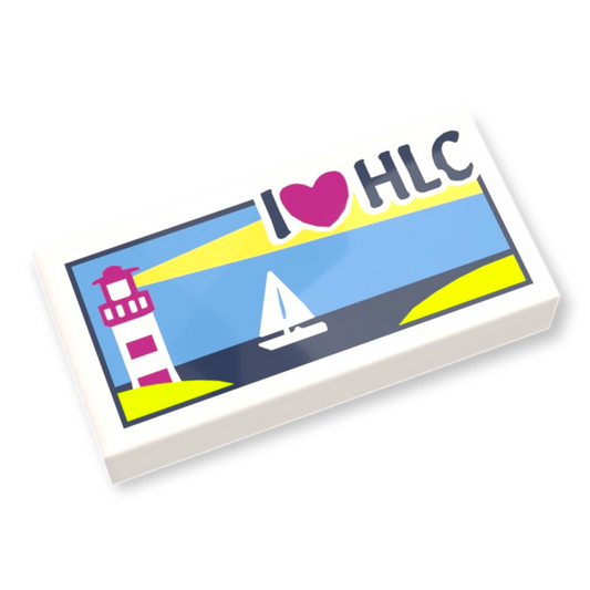 Diese LEGO® Tile 1x2 zeigt ein Leuchtturm-, Segelboot- und „I Heart HLC“-Muster